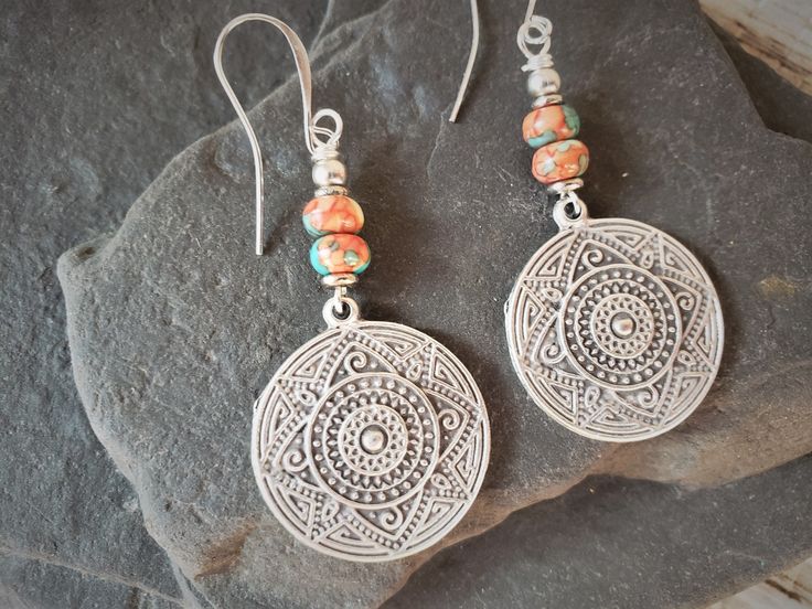 Bohemian Earrings with Mandala Dangle Boho style earrings with mandala charm and glass beads. The glass beads have beachy mixed colors of corals, blues, pinks and cream. Every bead is different, but just as beautiful.  Perfect earrings for those looking for a bohemian, beachy vibe. Very light weight Total hanging length is 2 1/2 inches. The mandala charm is the size of a quarter Traditional Nickel-free Earrings For Beach, Nickel-free Bohemian Earrings For Beach, Bohemian Nickel-free Earrings For Beach, Bohemian Single Drop Earring, Bohemian Round Earrings For The Beach, Bohemian Nickel-free Round Beaded Earrings, Nickel-free Round Beaded Earrings For Festival, Bohemian Drop Earrings, Bohemian Metal Earrings With Round Beads