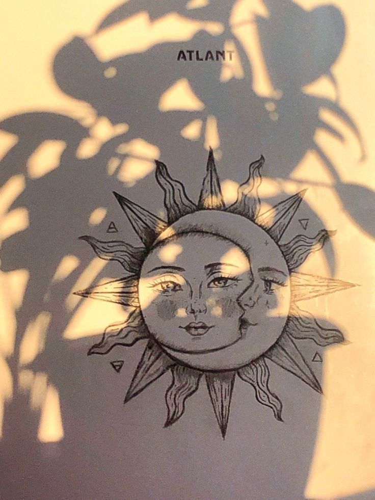 the shadow of a sun and moon on a wall