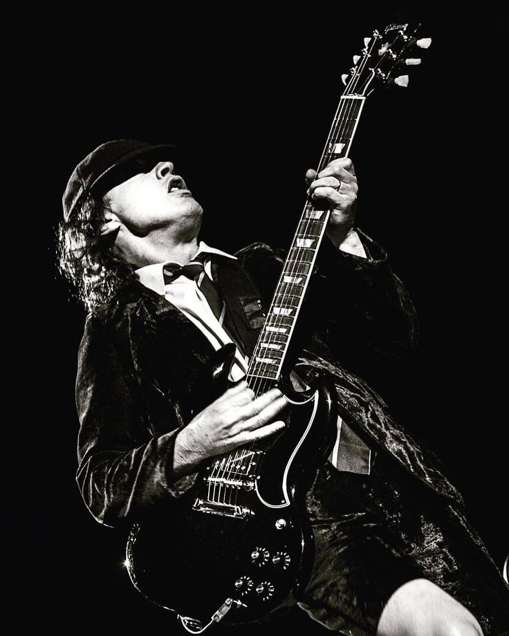 a black and white photo of a man playing an electric guitar