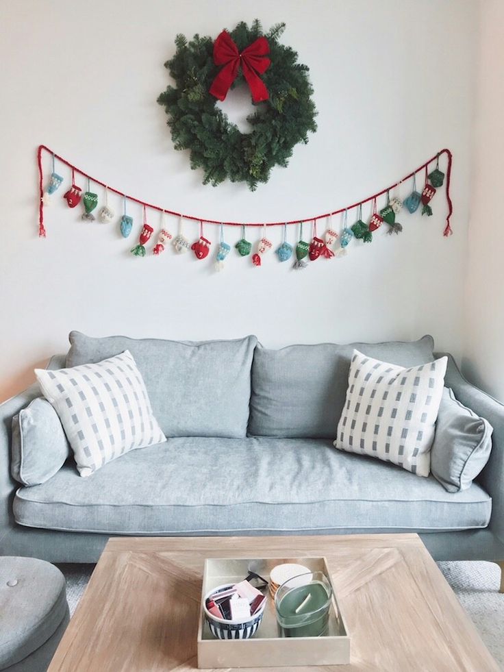 a living room filled with furniture and a christmas wreath on the wall over a coffee table