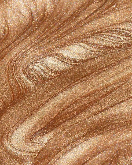 a close up view of the surface of a wood grained material with gold and brown tones