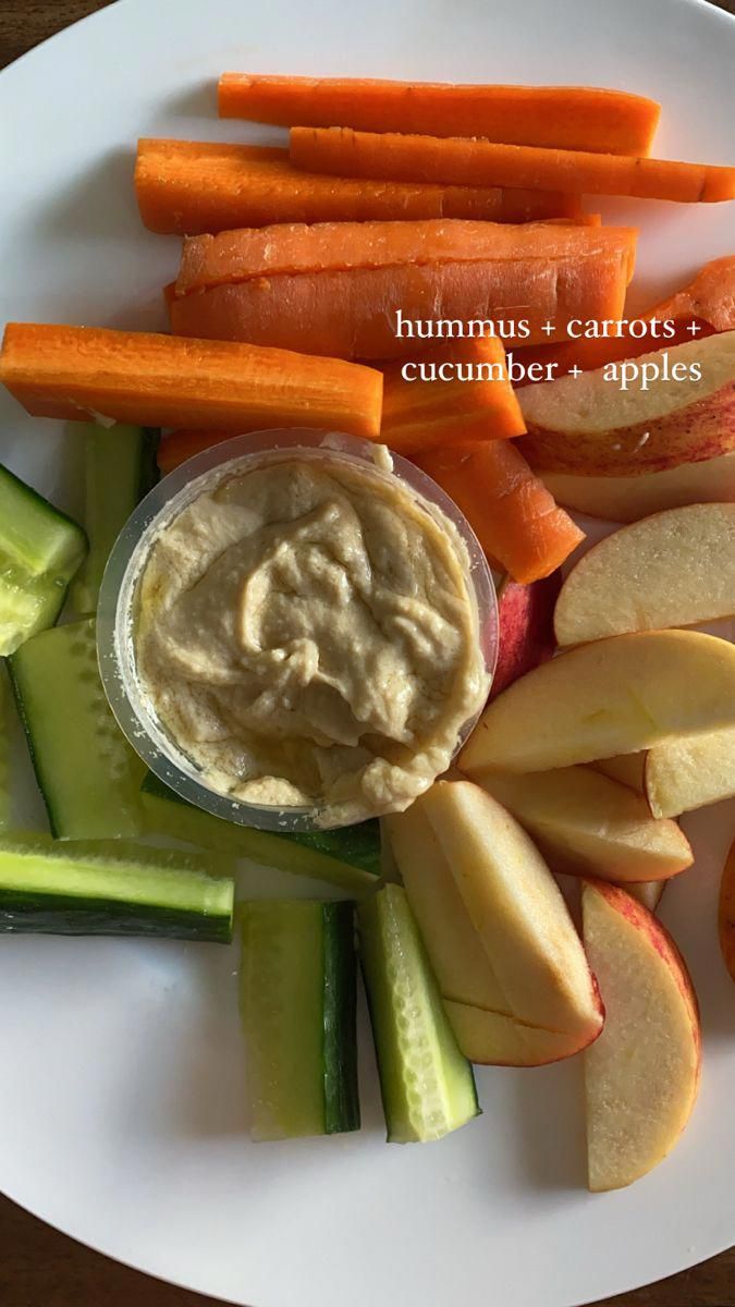 carrots, celery, and apples are arranged on a plate with dip