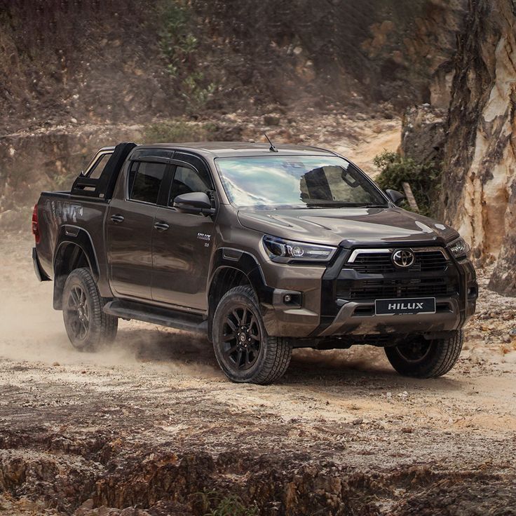 a gray truck driving down a dirt road