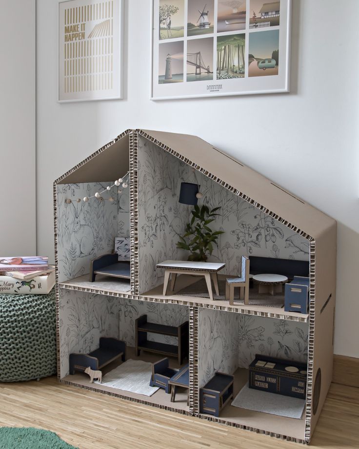 a doll house made out of cardboard on the floor