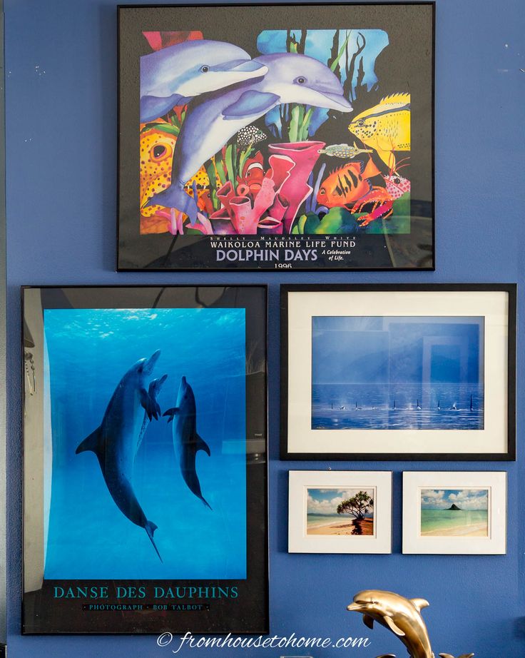 two dolphins are swimming in the water and some pictures on the wall