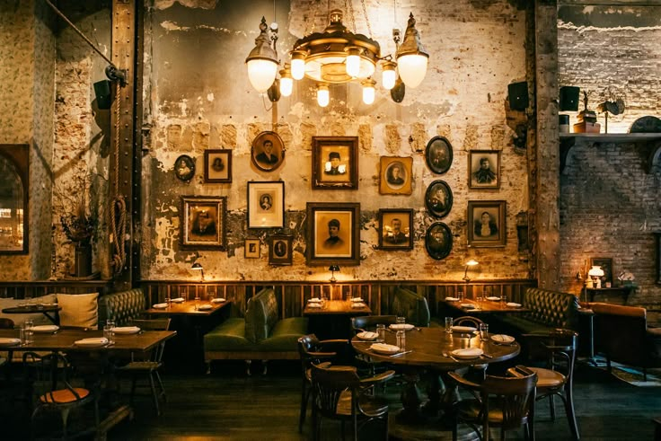 the interior of a restaurant with tables, chairs and pictures on the wall above them