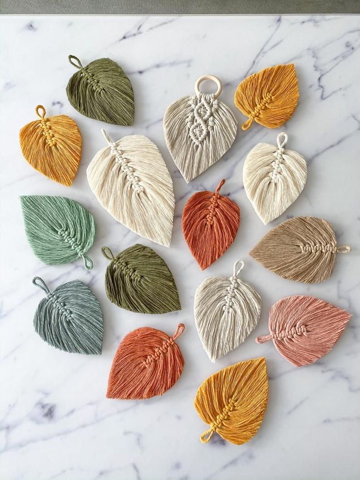 six different colors of tasseled leaves on a marble surface with white and green