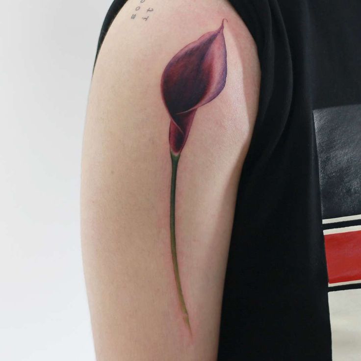 a woman with a tattoo on her arm has a single flower in the middle of her arm