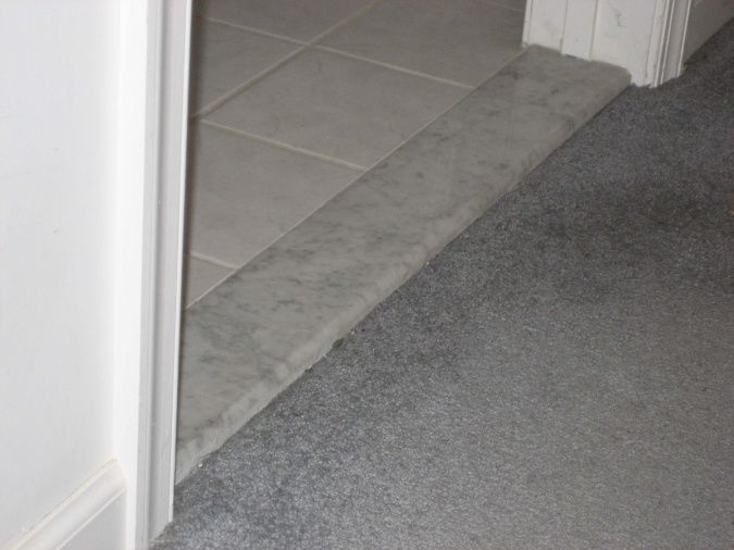 an open door leading into a room with gray carpet