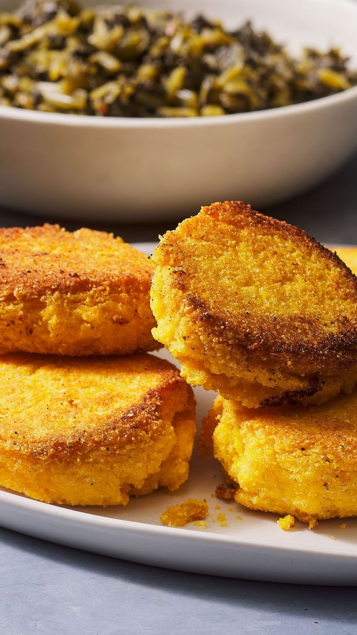 some fried food on a white plate next to a bowl