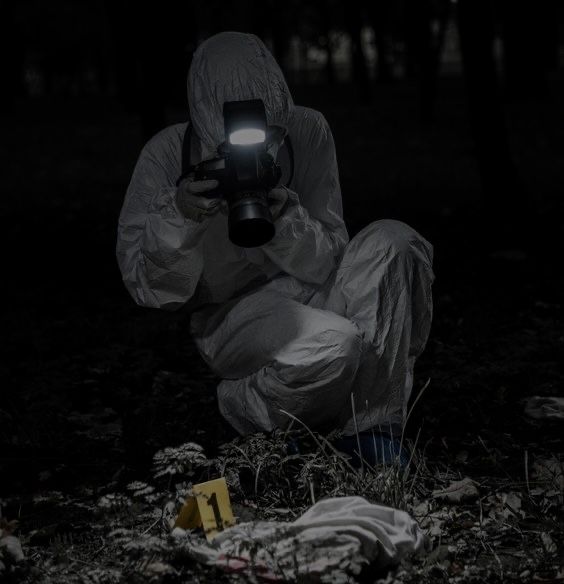 a person kneeling down in the dark with a flashlight