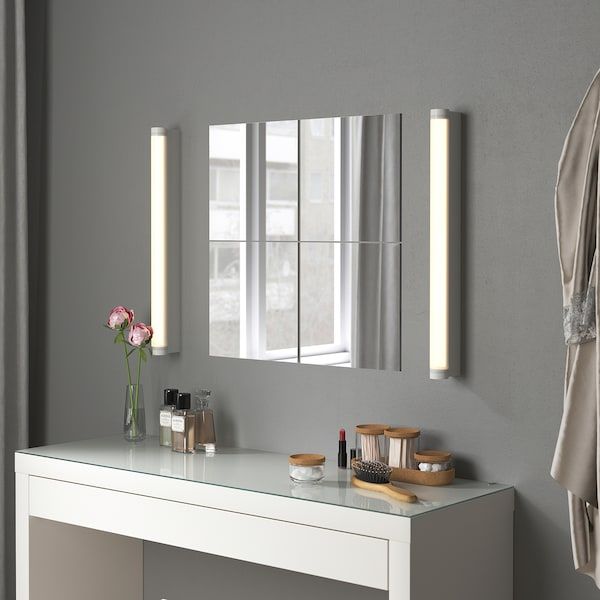 a bathroom with a white vanity, mirror and towel rack on the wall next to it