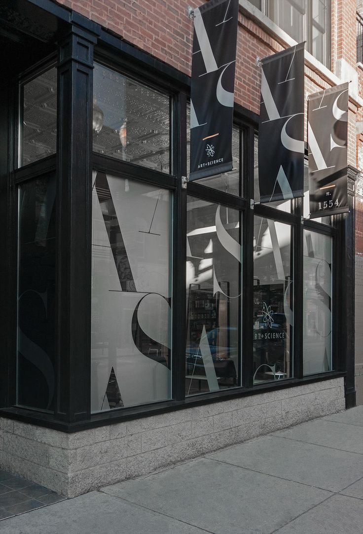 the storefronts are decorated with black and white letters on them, as well as large windows