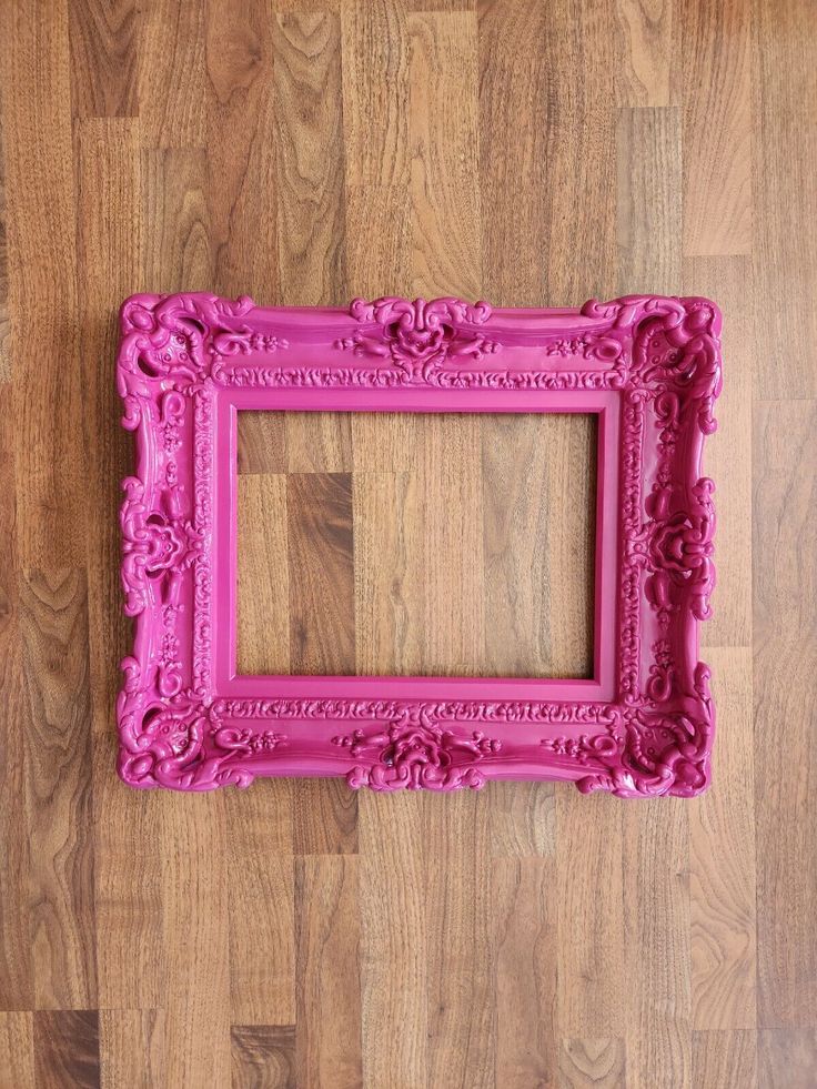 a pink frame sitting on top of a wooden floor