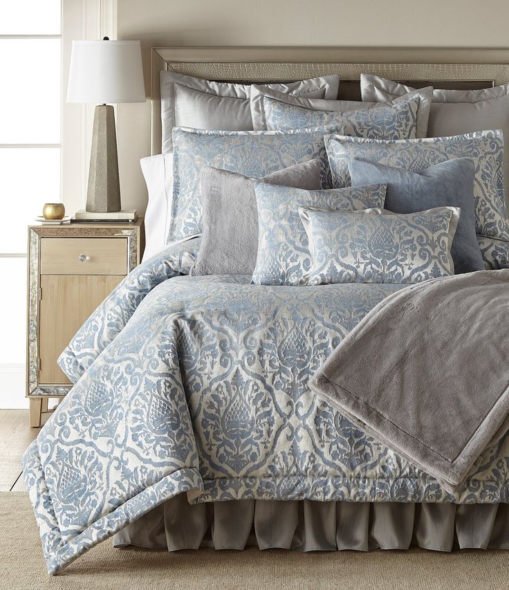 a bed with blue and white comforters in a bedroom