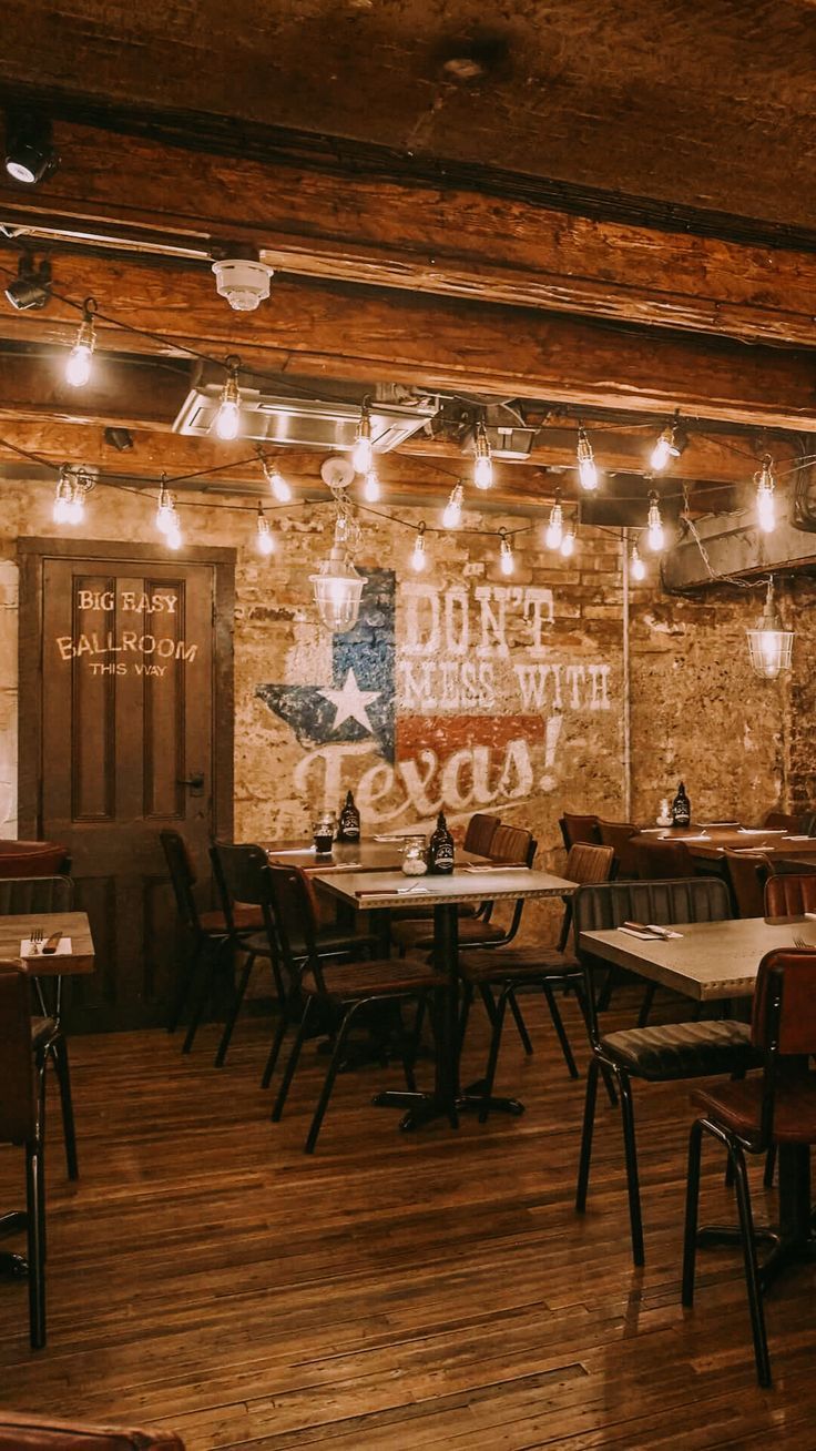 the inside of a restaurant with tables and chairs in front of a brick wall that says don't mess with you