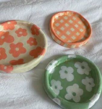 three small bowls sitting on top of a white sheet