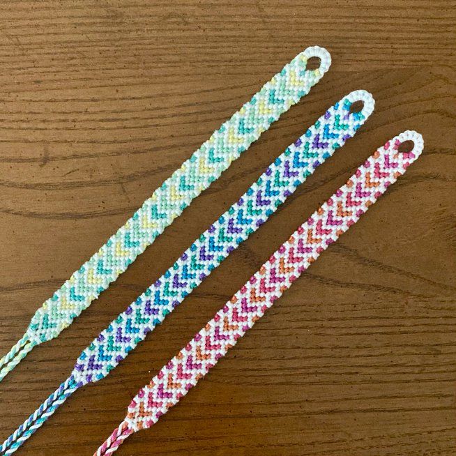 two colorful bracelets sitting on top of a wooden table