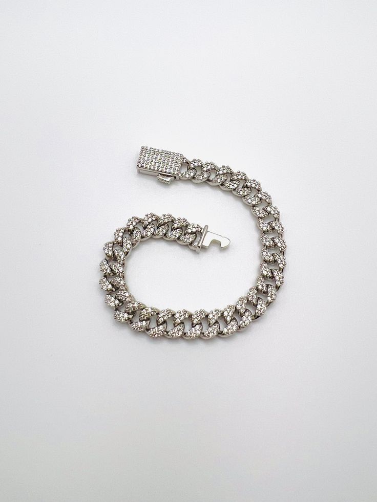 Description: Cuban chain bracelet encrusted with cubic zirconia. Material: Rhodium plated brass, 3A cubic zirconia Measurement: 7" length, 8mm width Tarnish resistant, water resistant, hypoallergenic Luxury Cuban Link Bracelet In Diamond White Cubic Zirconia, Luxury Diamond White Bracelets With Rhinestones, Silver Diamond Chain Bracelets, Luxury White Gold Bracelets With Rhinestones, Luxury White Gold Bracelet With Rhinestones, Elegant White Gold Cuban Link Bracelet With Cubic Zirconia, Luxury Cuban Link Bracelet In Diamond White, Luxury Iced-out Cubic Zirconia Chain Bracelet, Cuban Link White Gold Chain Bracelet With Diamond Accents