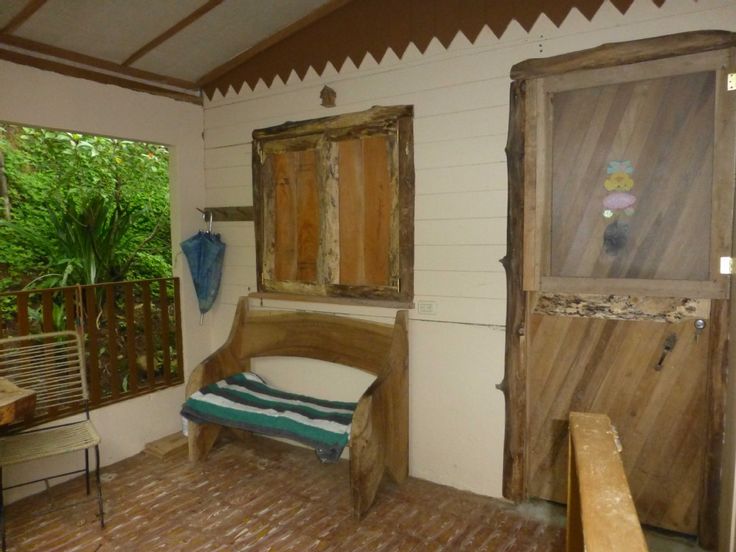 a wooden bench sitting on top of a hard wood floor next to a door and window