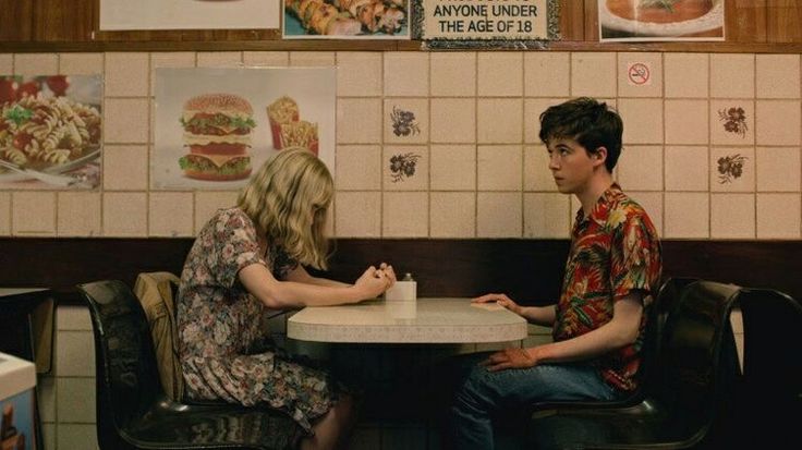 two people sitting at a table in a fast food restaurant