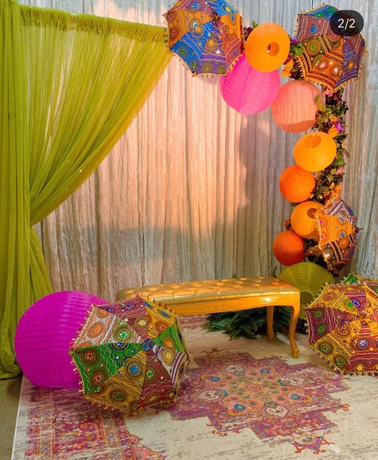 there are many different colored umbrellas on the floor in front of a stage curtain