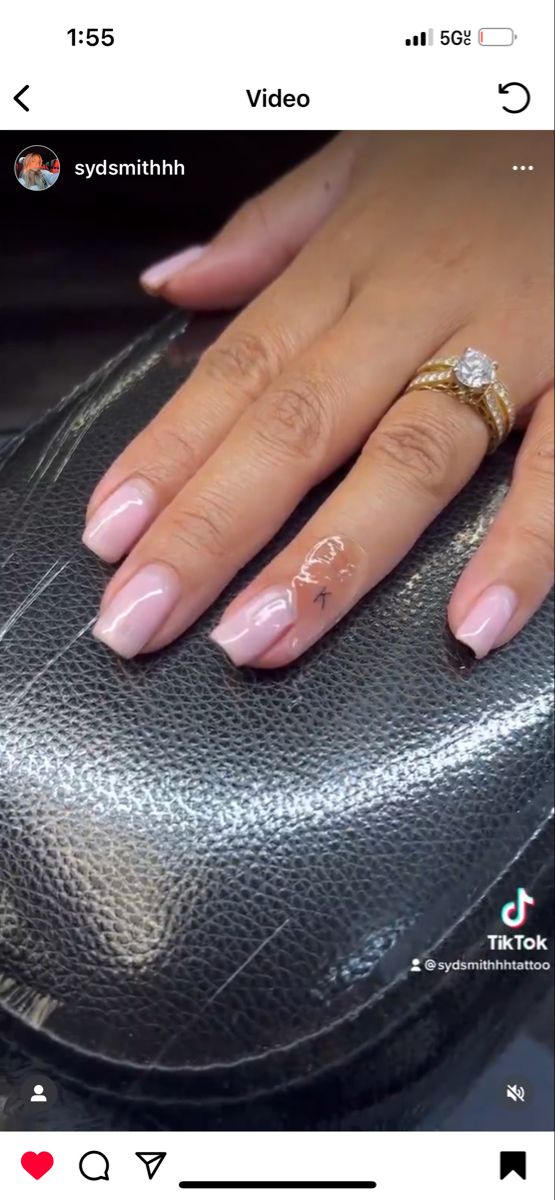 a woman's hand with pink manies and a ring on top of her finger