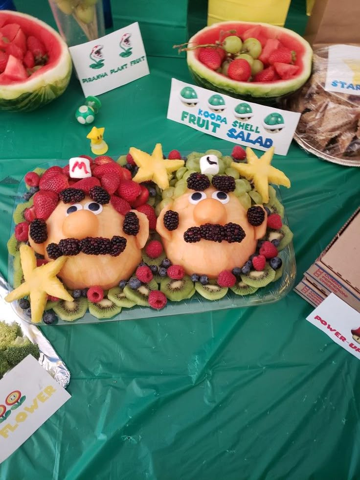 a table topped with lots of fruits and veggies covered in cartoon characters on top of it