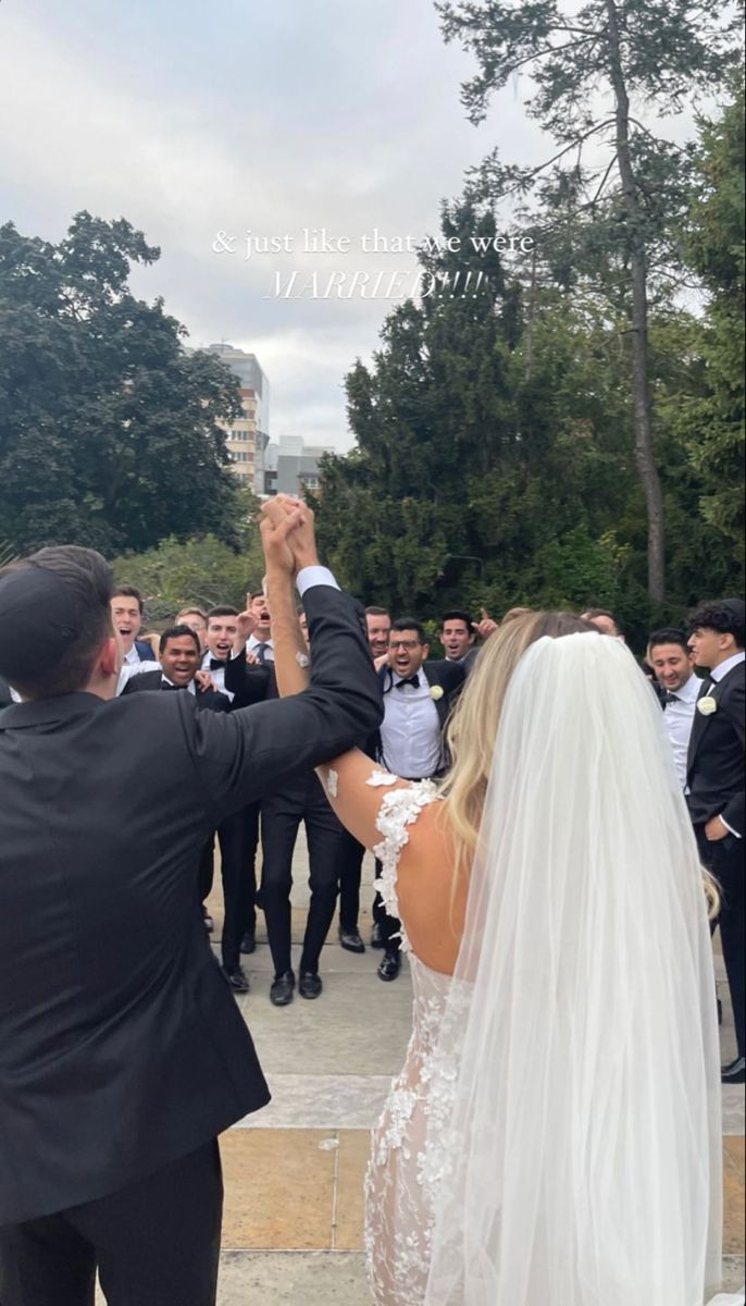 the bride and groom are taking pictures with their cell phones in front of an audience