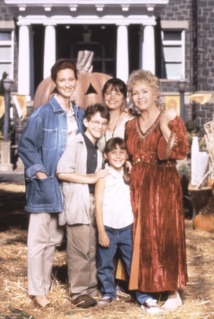 a group of people standing next to each other in front of a house