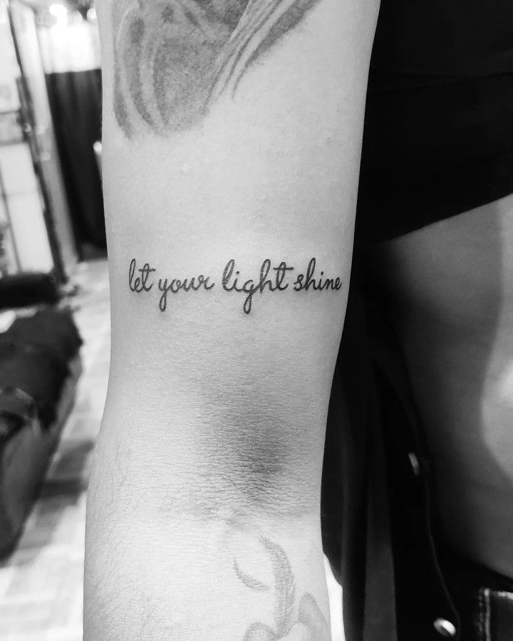 a person with a tattoo on their arm that says, be your light shine