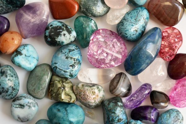 many different colored rocks and stones on a white surface