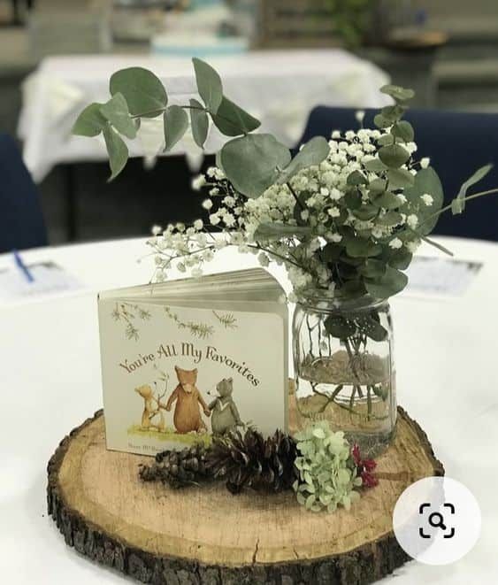 a vase filled with flowers sitting on top of a wooden table next to a book