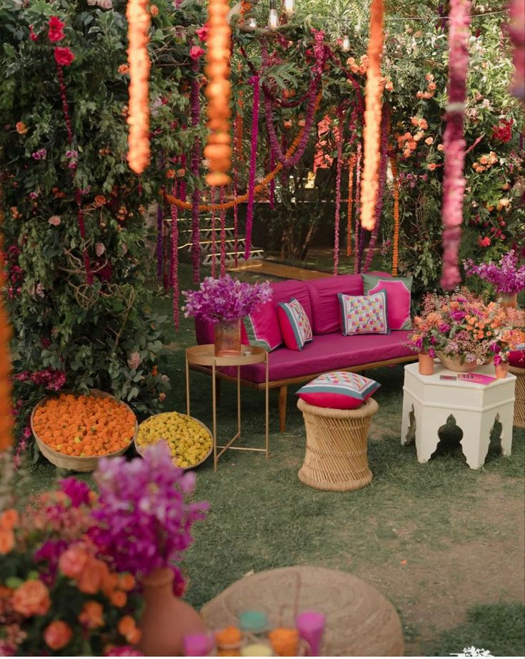 an outdoor seating area with pink couches and flowers