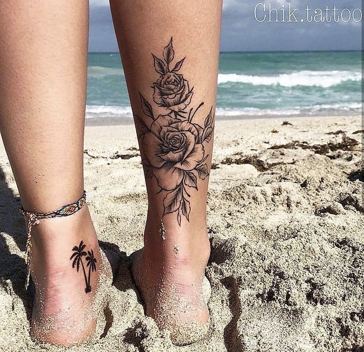 a woman's feet with tattoos on the beach