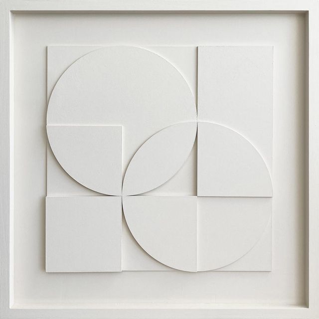 an abstract art piece with white paper cut into circles and rectangles in the center