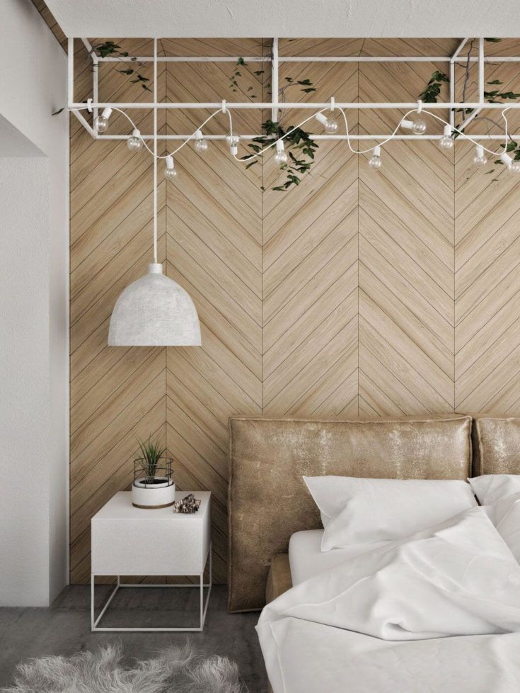 a white bed sitting next to a wooden wall with plants growing on the headboard