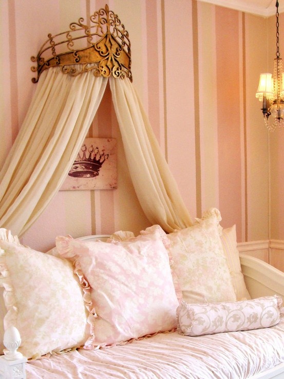 a canopy bed with pillows on it in front of a pink wallpapered room