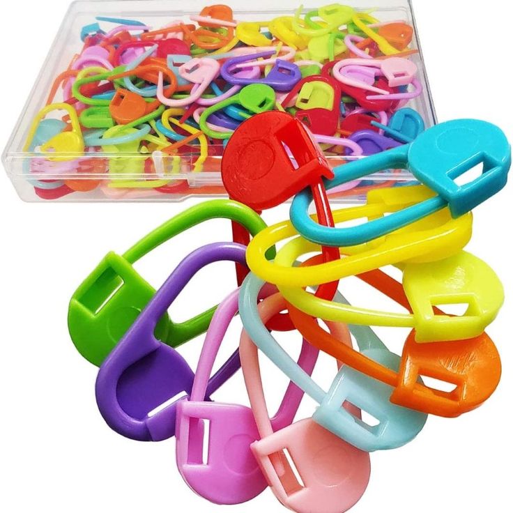 a plastic container filled with lots of different colored scissors and clips on top of each other