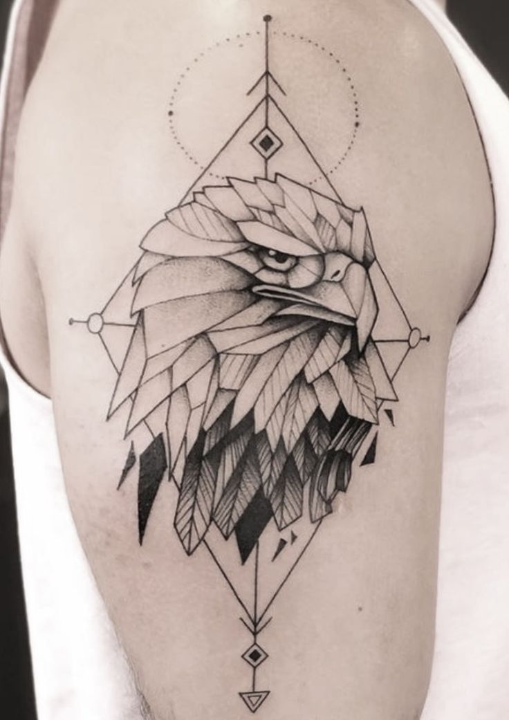 an eagle tattoo on the back of a man's shoulder, with geometric shapes around it