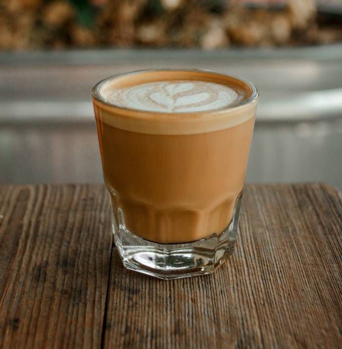 a cup of coffee sitting on top of a wooden table