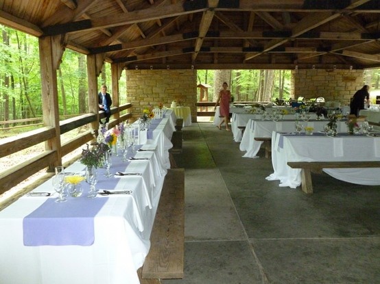 the tables are set up for an outdoor wedding reception with white tablecloths and blue runneres