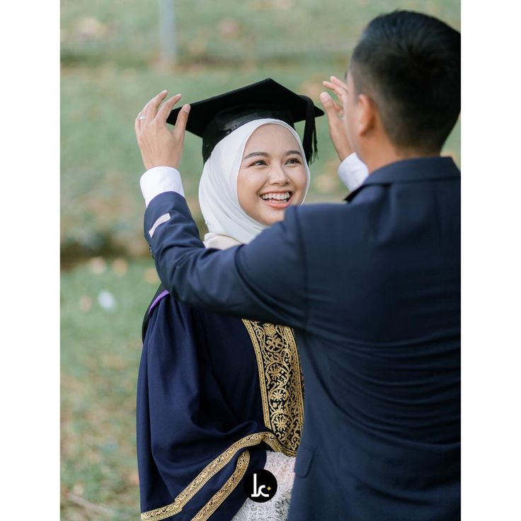 a woman in a graduation cap and gown is being congratulated by a man