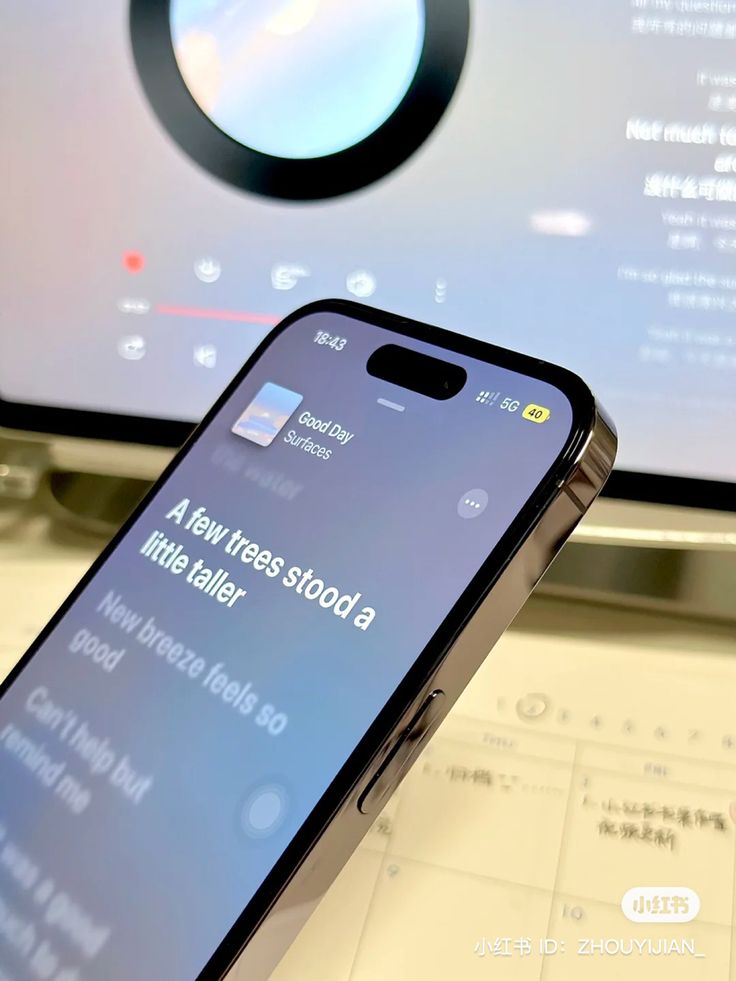 a cell phone sitting on top of a desk next to a monitor