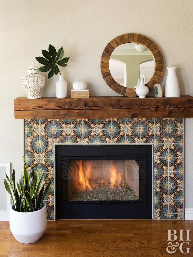 a living room with a fire place and potted plants on the fireplace mantel