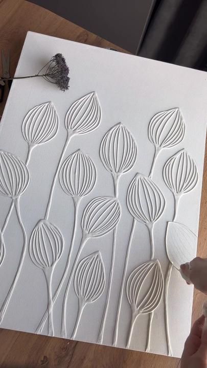 a person is working on an art project with white paper and scissors, which are sitting on a wooden table