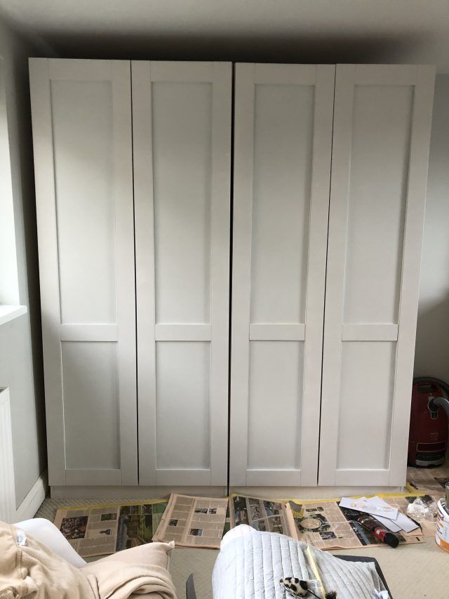 a bedroom with white closet doors and papers on the floor