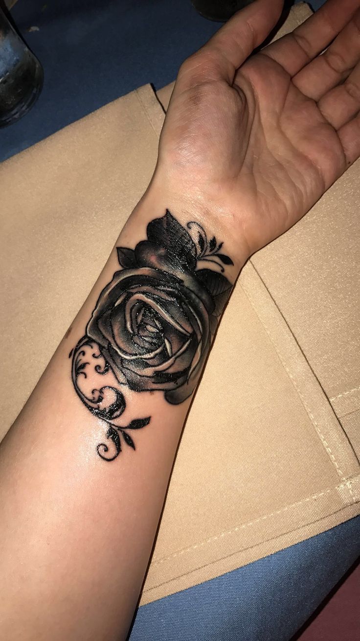 a woman's arm with a rose tattoo on it