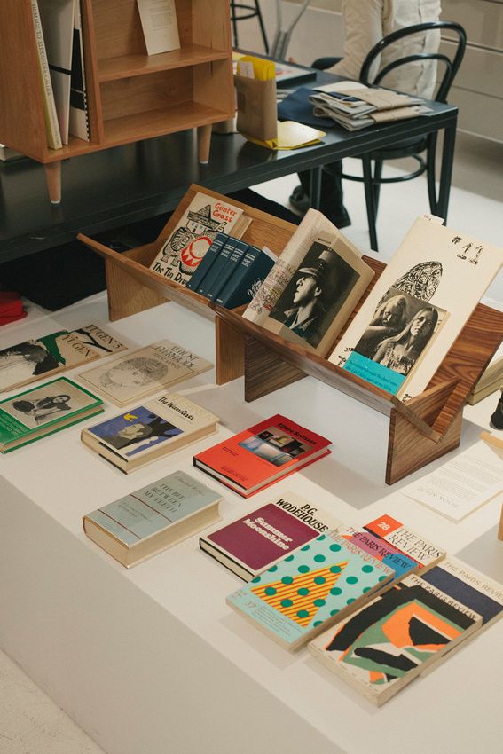 an assortment of books on display in a room with chairs and desks behind them