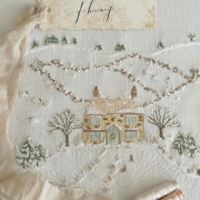 a piece of cloth with a house and trees on it